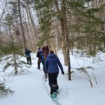 Volunteers snowshoeing to Slaughter Pond