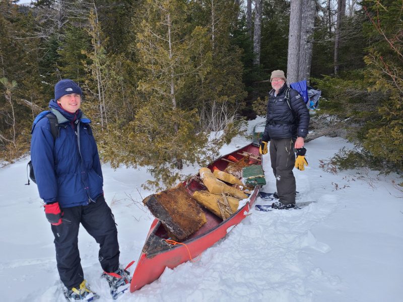 Chris Richmond and his son Carlton with an old canoe on snow