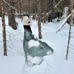 Volunteer dragging part of a canoe on snow