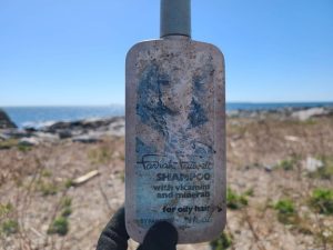 Vintage plastic shampoo bottle found washed ashore on Eastern Egg Rock with other marine debris and trash.