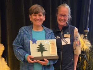 Two people holding an award at the Maine Tourism Conference